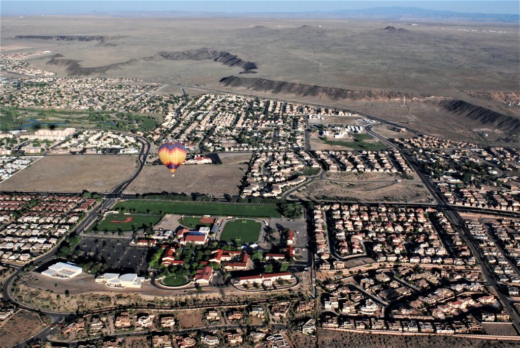 Aerial view of a suburb in the desert, with a hot air balloon in the middle