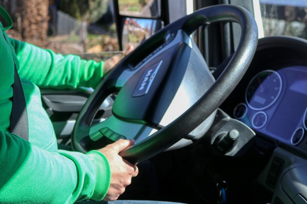 Two hands and arms are visible driving a steering wheel.