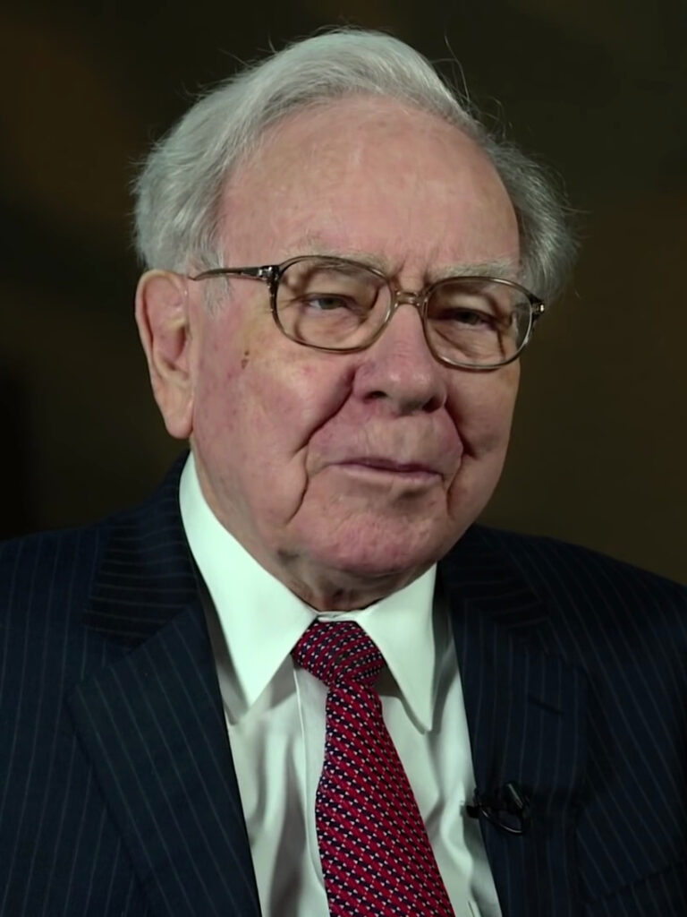Warren Buffet wearing a suit and glasses.